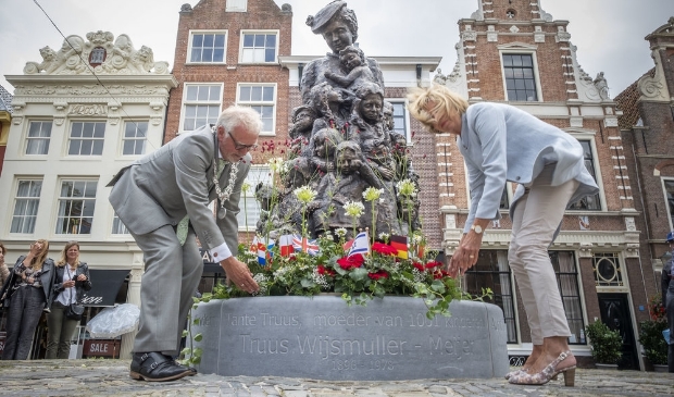 Burgemeester Piet Bruinooge en zijn echtgenote leggen een bloemstuk bij het beeld van Truus.