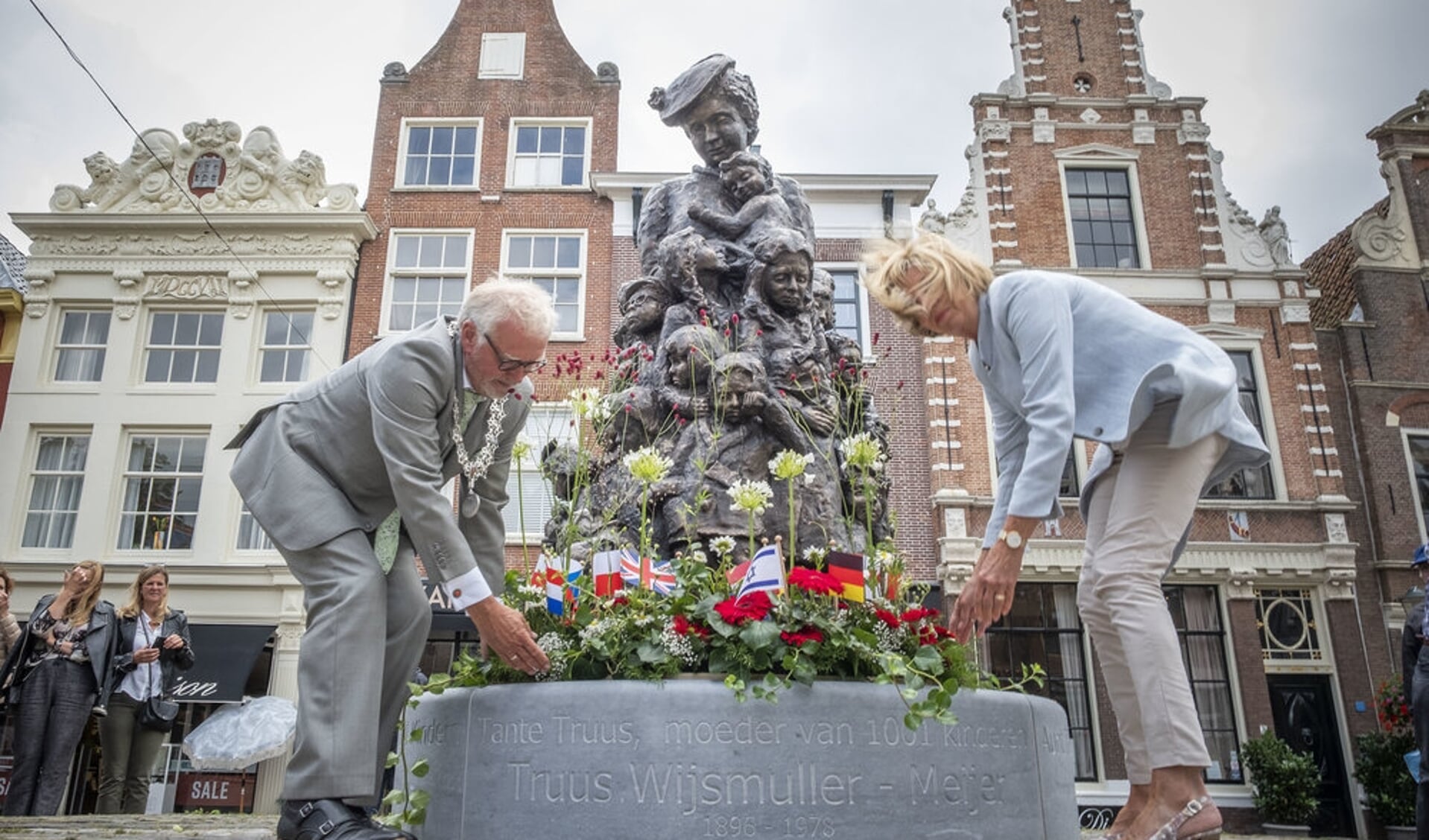 Burgemeester Piet Bruinooge en zijn echtgenote leggen een bloemstuk bij het beeld van Truus.