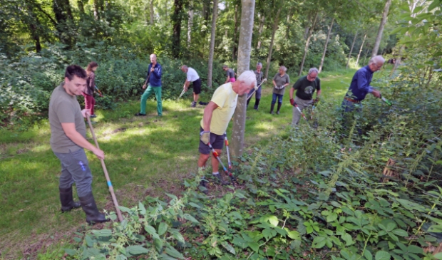 De Hoeders druk in de weer met het verwijderen van onkruid rondom Huis Nijenburg.