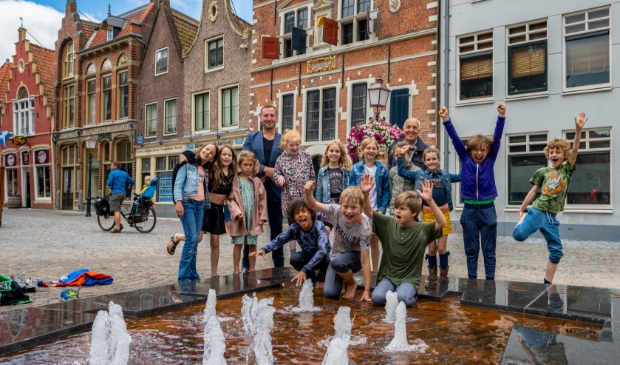 Kinderen van de Montessorischool proberen samen met wethouder Samir Bashara de fontein uit.