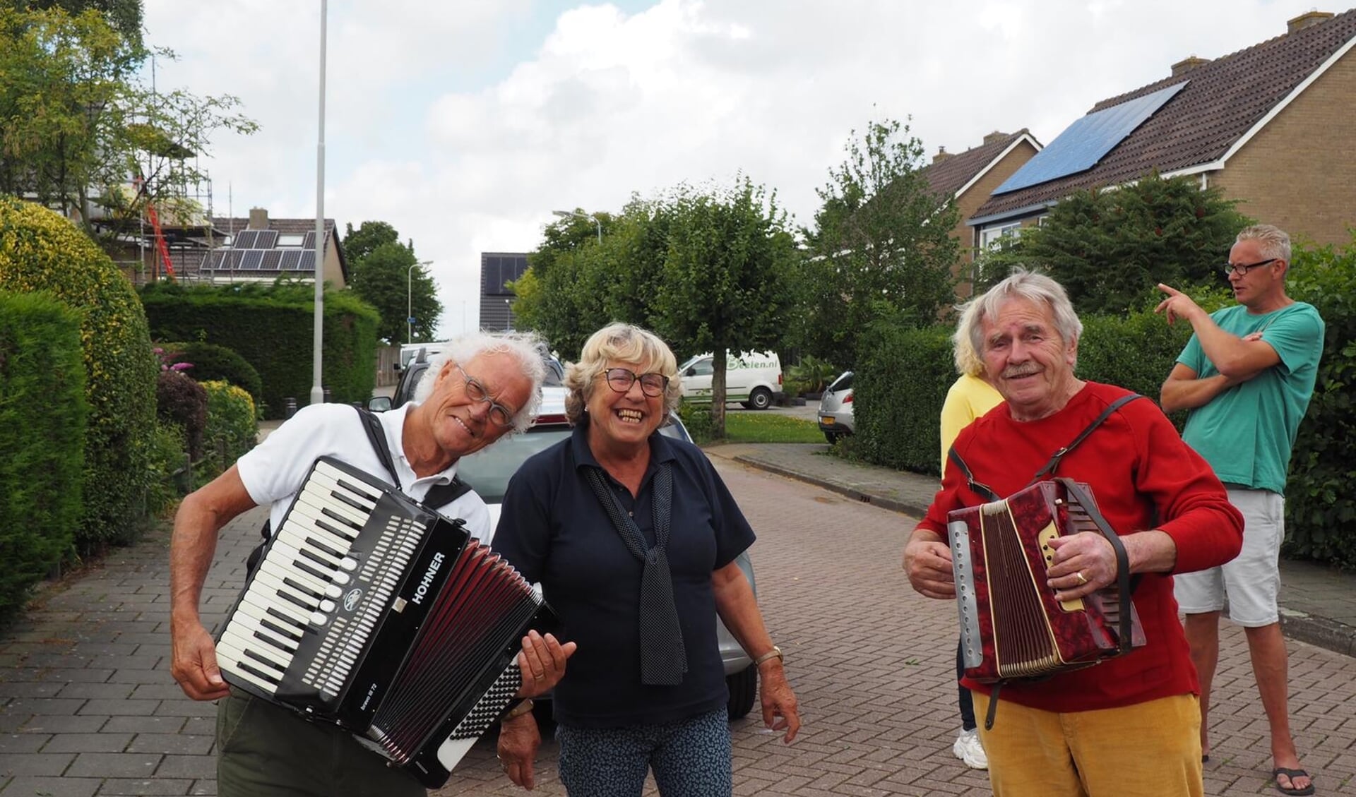 Muzikanten spelen troostmuziek in de Startingerstraat, met tussen hen in Joke de Wit.