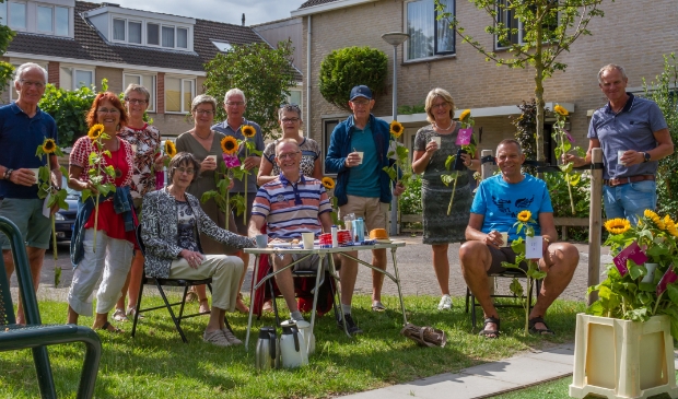 <p>Nico en Willly lute (achter het tuinsetje) en hun familieleden worden verrast met bloemen en muziek.</p>