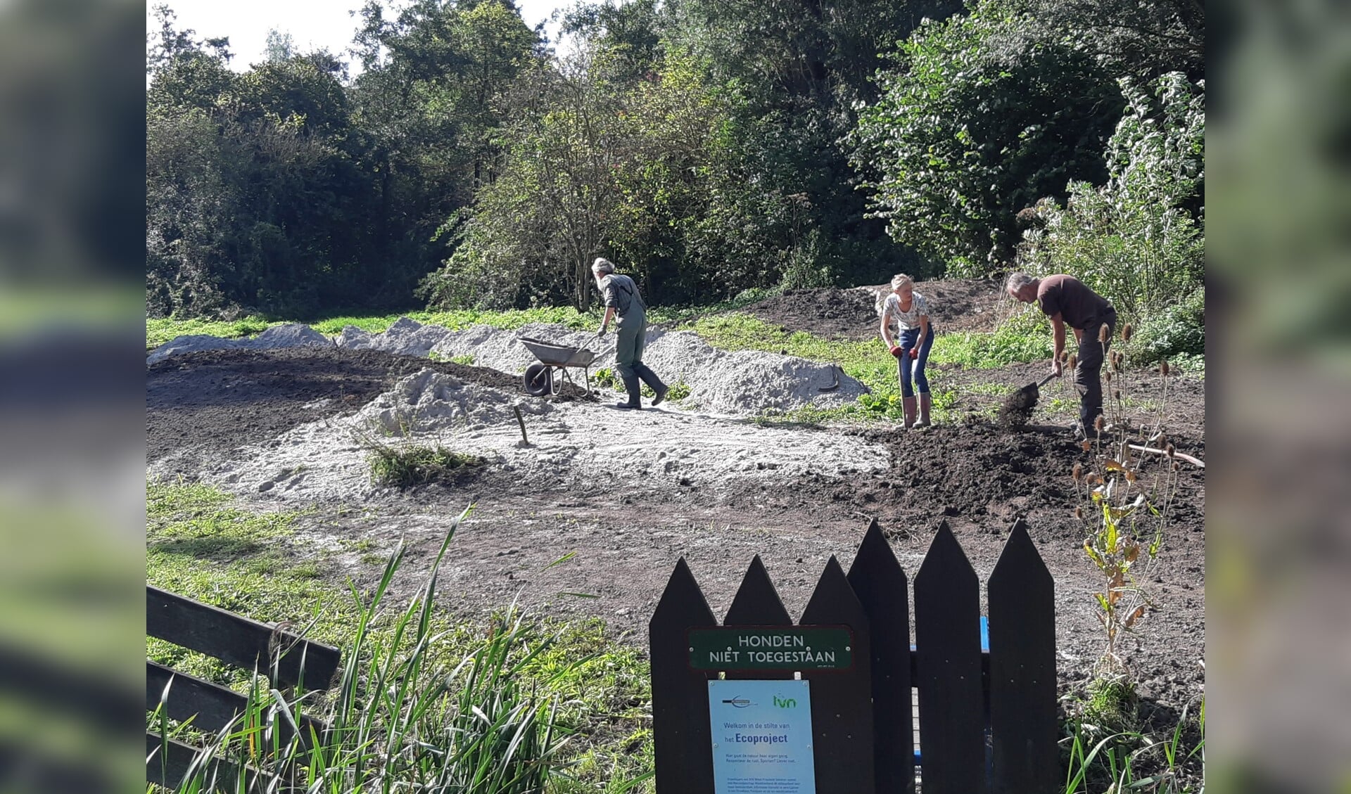 Vrijwilligers storten zand op plek IVN Ecoproject Streekbos.