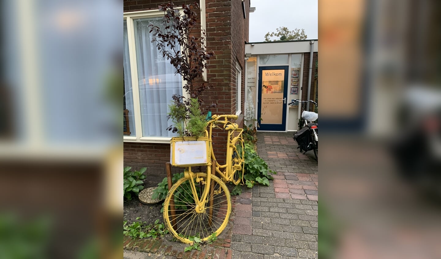 De gele fiets van (de helaas afgelaste Kunstfietsroute) staat te 'shinen' voor de naaischool.