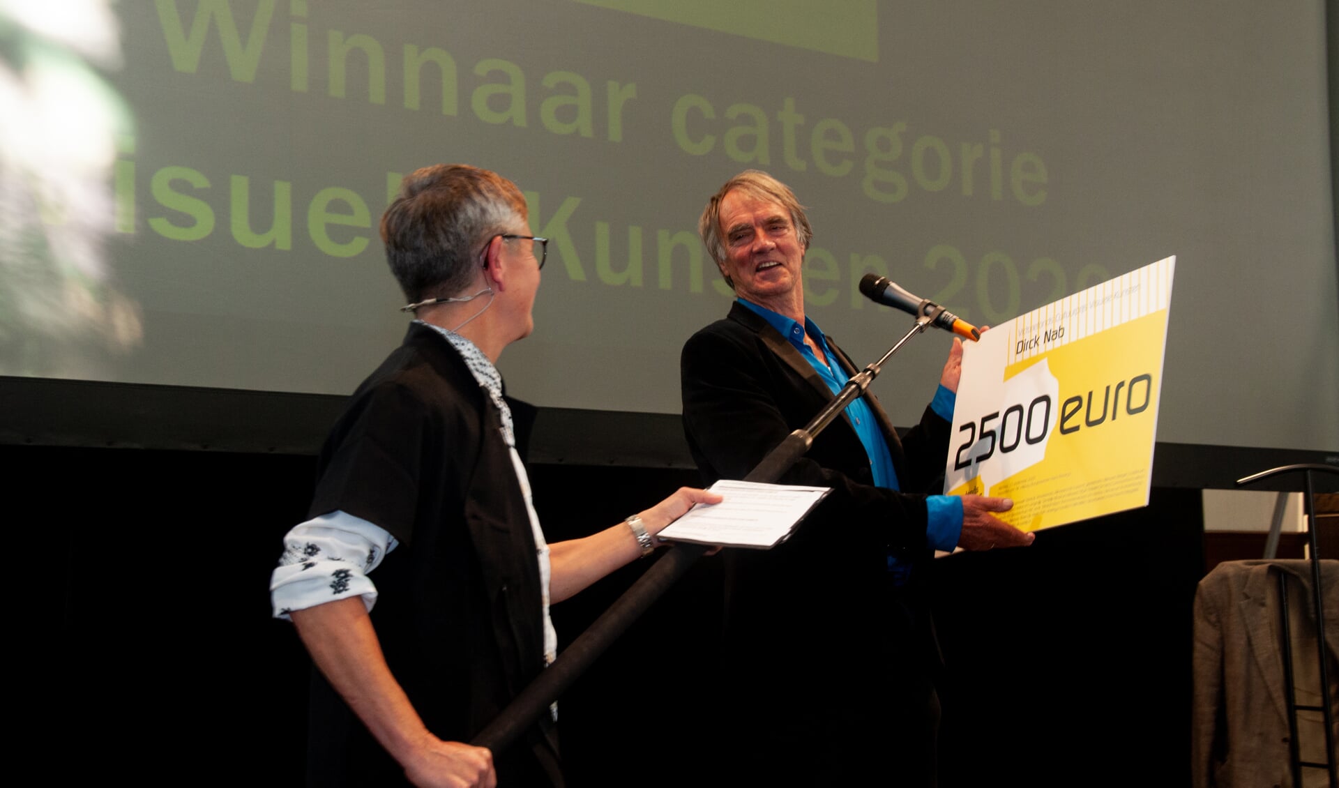 Dirck Nab ontvangt de Victoriefonds Cultuurprijs uit handen van juryvoorzitter en burgemeester van Heiloo Hans Romeyn. 