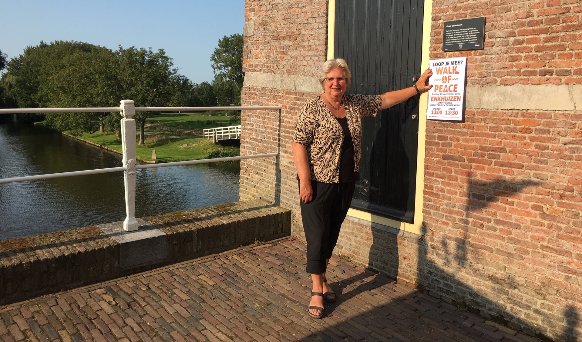 Louise Kooiman bij waterpoort Oude Gouwsboom waar een gedicht over kindvluchtelingen wordt voorgelezen.
