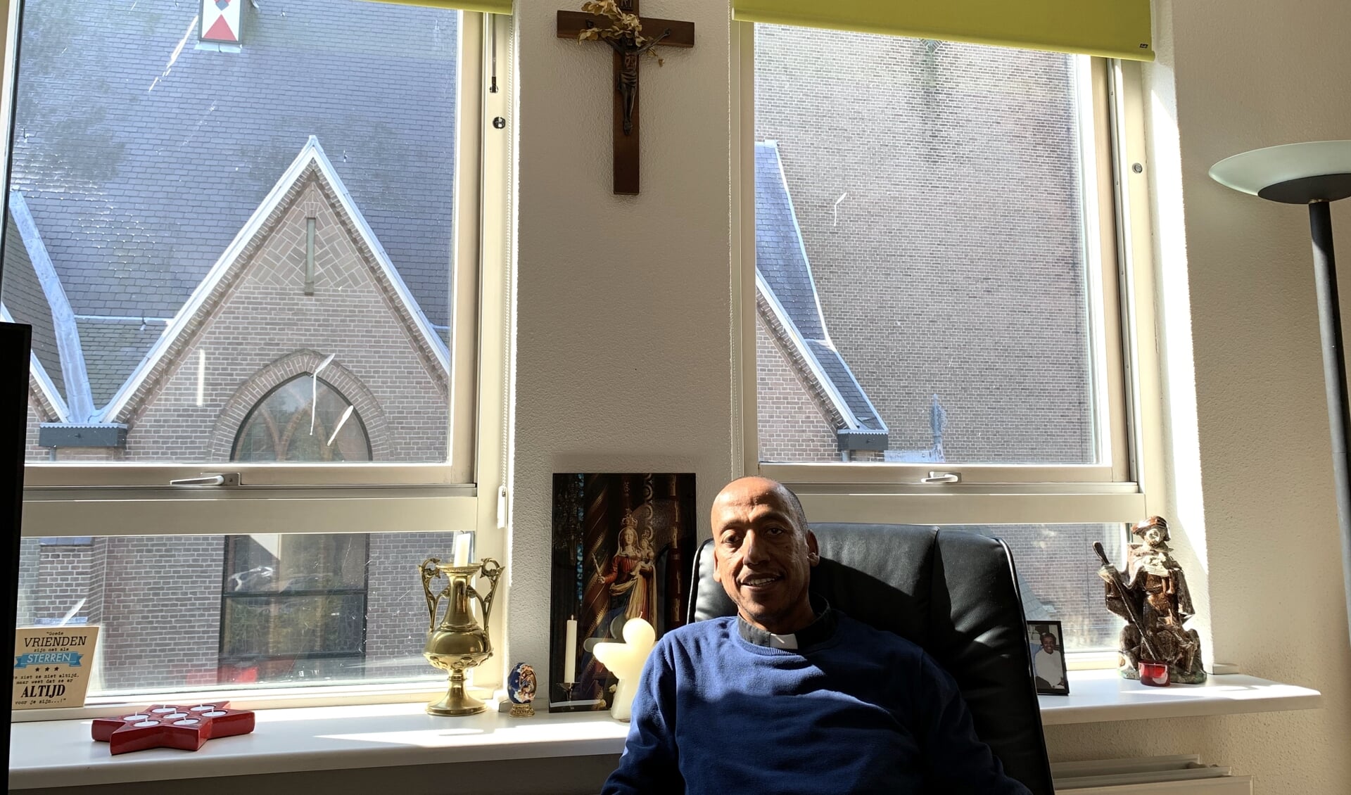 Pastoor Kaleab Masresha Shiferaw in zijn woonkamer naast de kerk.