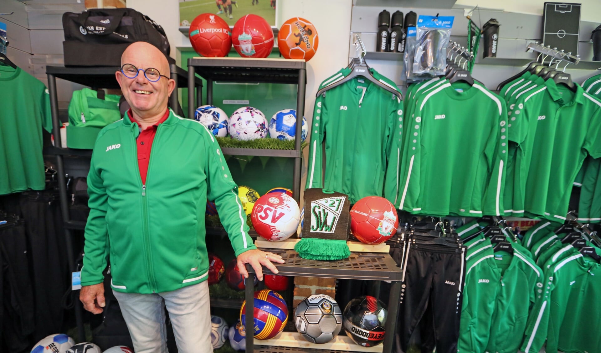 Peter de Boer in zijn kledingshop, waar diverse accessoires en SVW'27 clubkleding te koop is.