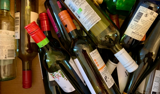 <p>Lege drankflessen onderweg naar de glasbak.</p>