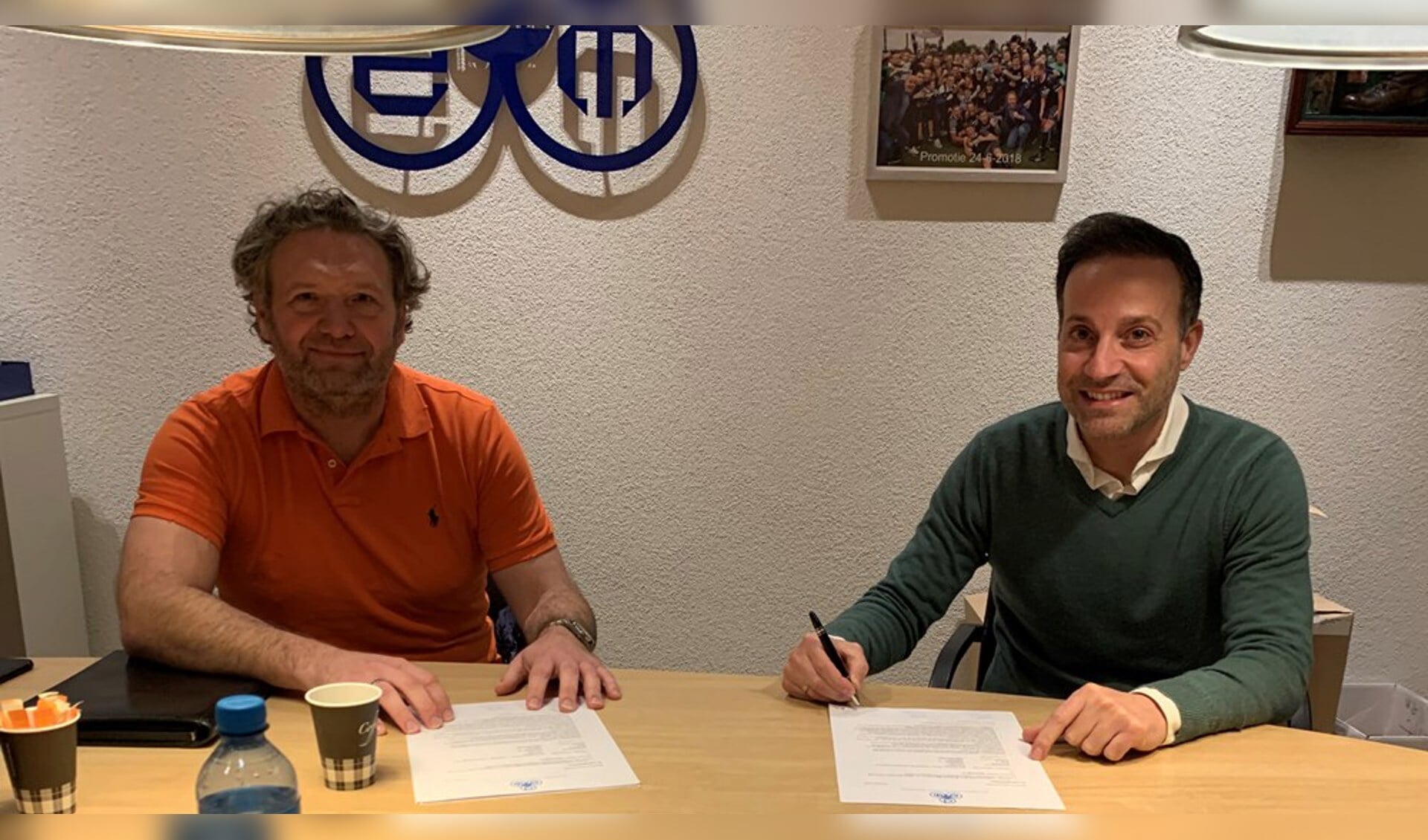 DEM-voorzitter Van der Ven (links) en trainer Kalaitzis ondertekenen het contract.