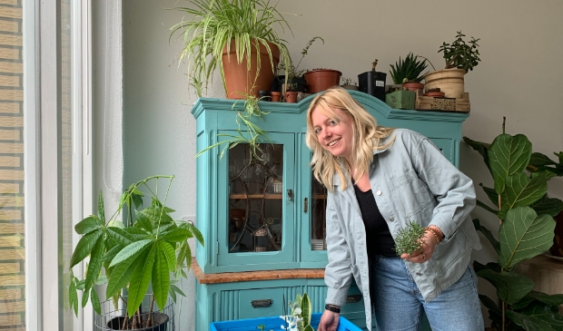 <p>Mirthe Stoop bij een krat vol adoptieplanten. "Linda, kom jij je plantje nog ophalen?</p>