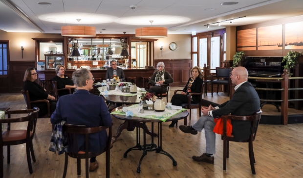 <p>In het Grand Café van woonzorglocatie De Hoge Hop in Hoorn, waar voor de coronamaatregelen activiteiten en samenkomsten voor bewoners plaatsvonden, bespreken de deelnemers aan het werkbezoek de situatie in de zorg. </p>
