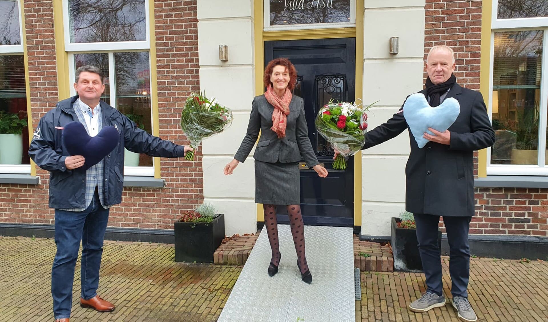 Jan Kuin (r) en Peter Langenberg overhandigen een hart als symbool voor de gulle donatie aan Marjolijn Dölle, voorzitter van Stichting Inloophuis Pisa.