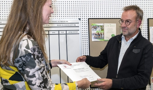 <p>De heer Veeter ontvangt bijbehorende oorkonde uit handen van burgemeester Anja Schouten.</p>
