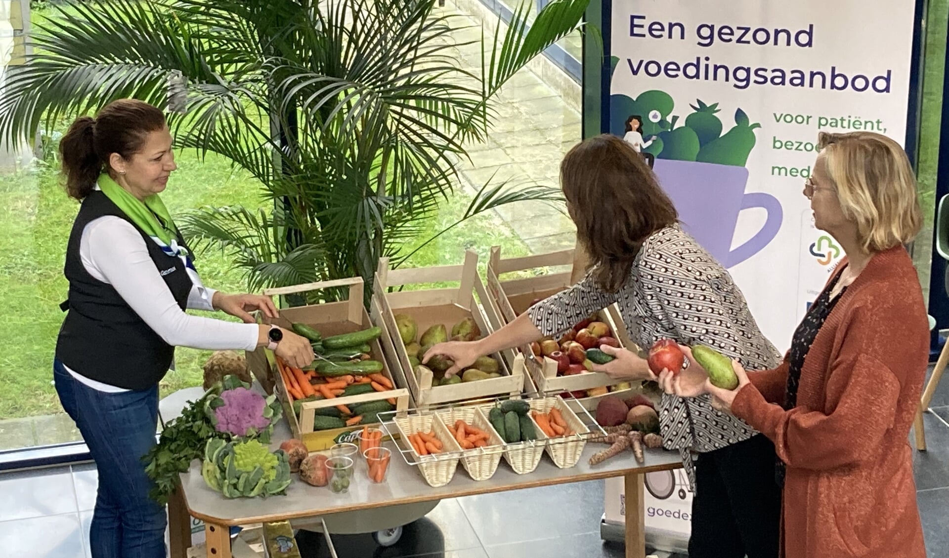 Een gastvrouw van het Dijklander Ziekenhuis in Purmerend deelt groente en fruit uit aan patiënten en medewerkers