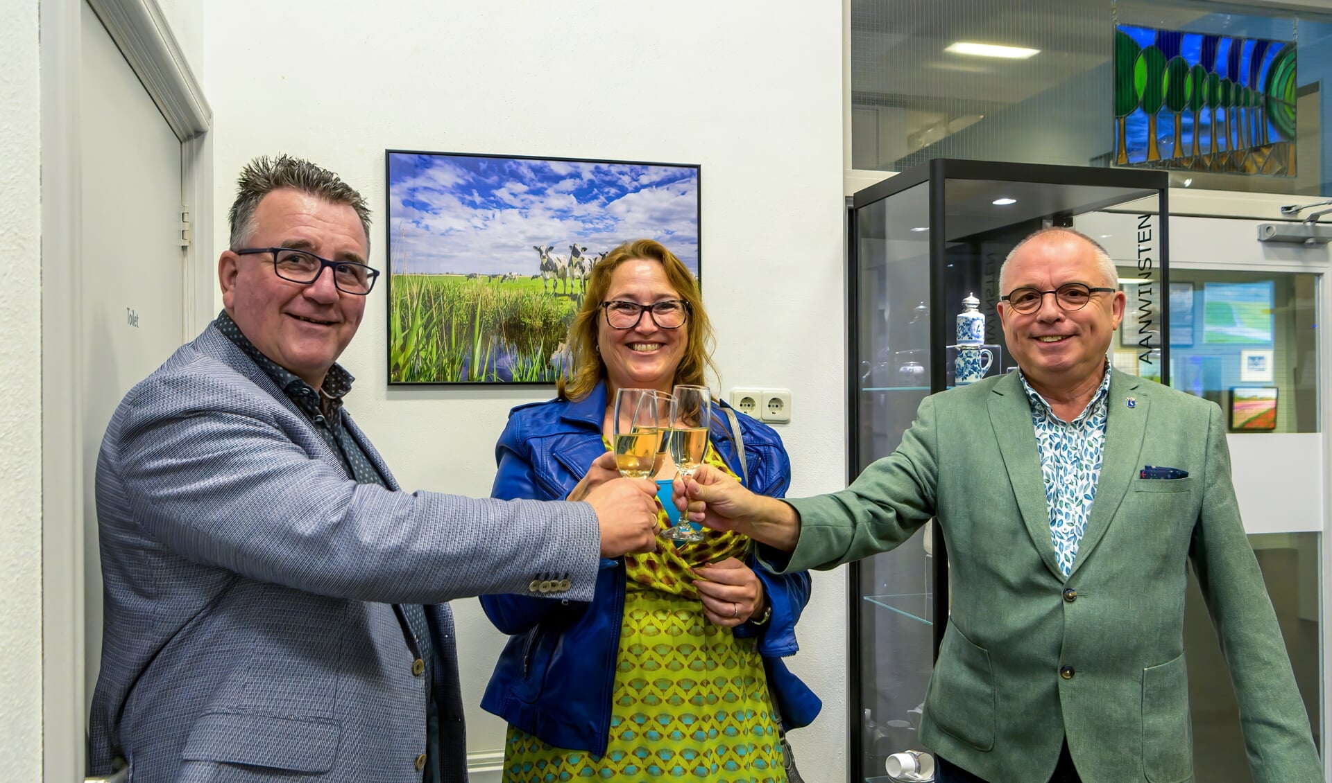 Caroline Pleysier toost met wethouders Mario Hegger en Jeroen Schalkwijk op haar winnende foto (op de achtergrond).