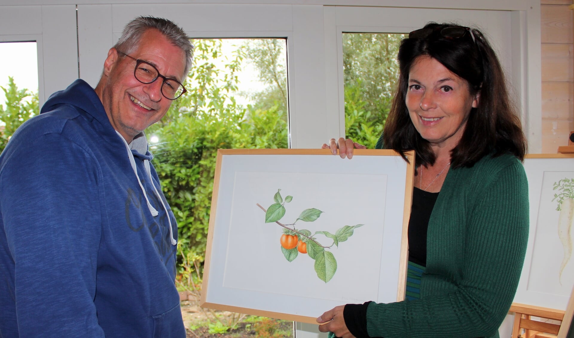 Botanisch kunstenares Eline Hoogendijk in haar atelier met bezoeker Rick Yark. Zij gaat ook exposeren in het Boomkwekerijmuseum. 
