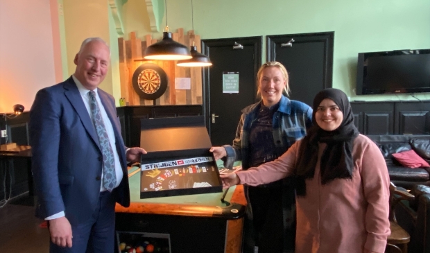 <p>Burgemeester Van Zuijlen overhandigt het spel aan jongerenwerkers in Enkhuizen.</p>