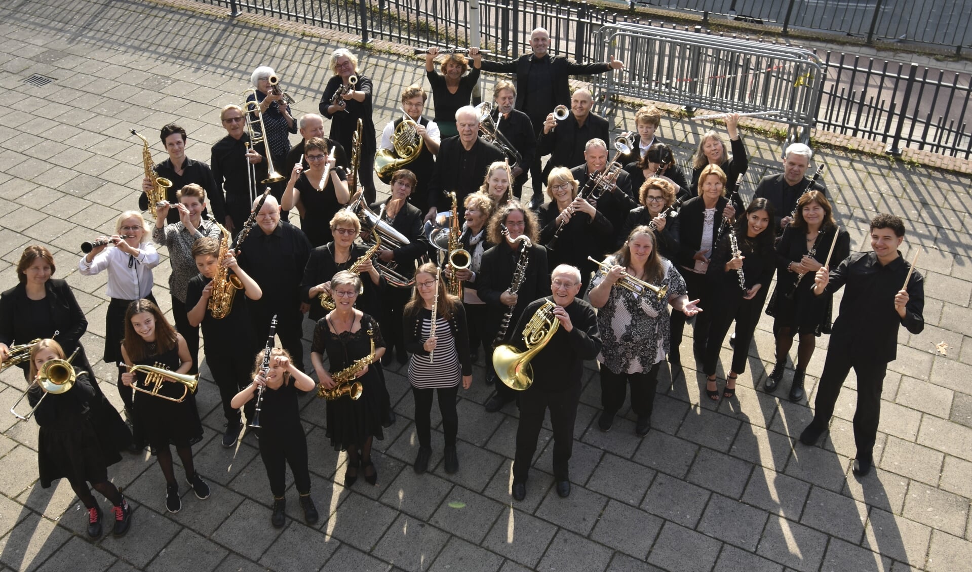 Groepsfoto met alle musicerende leden van het orkest.  
