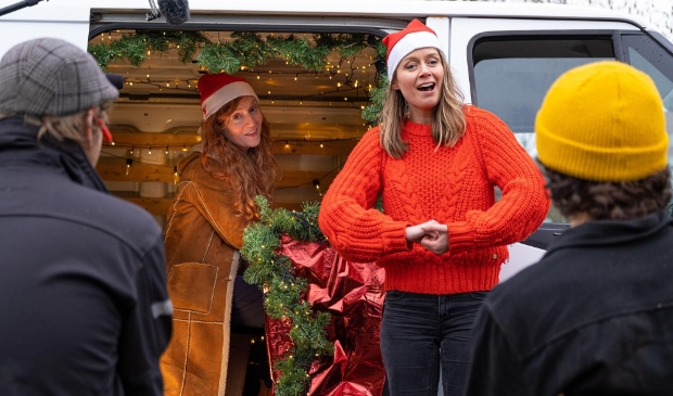 <p>Maartje en Kine bij de in kerststijl versierde kerstbus.</p>
