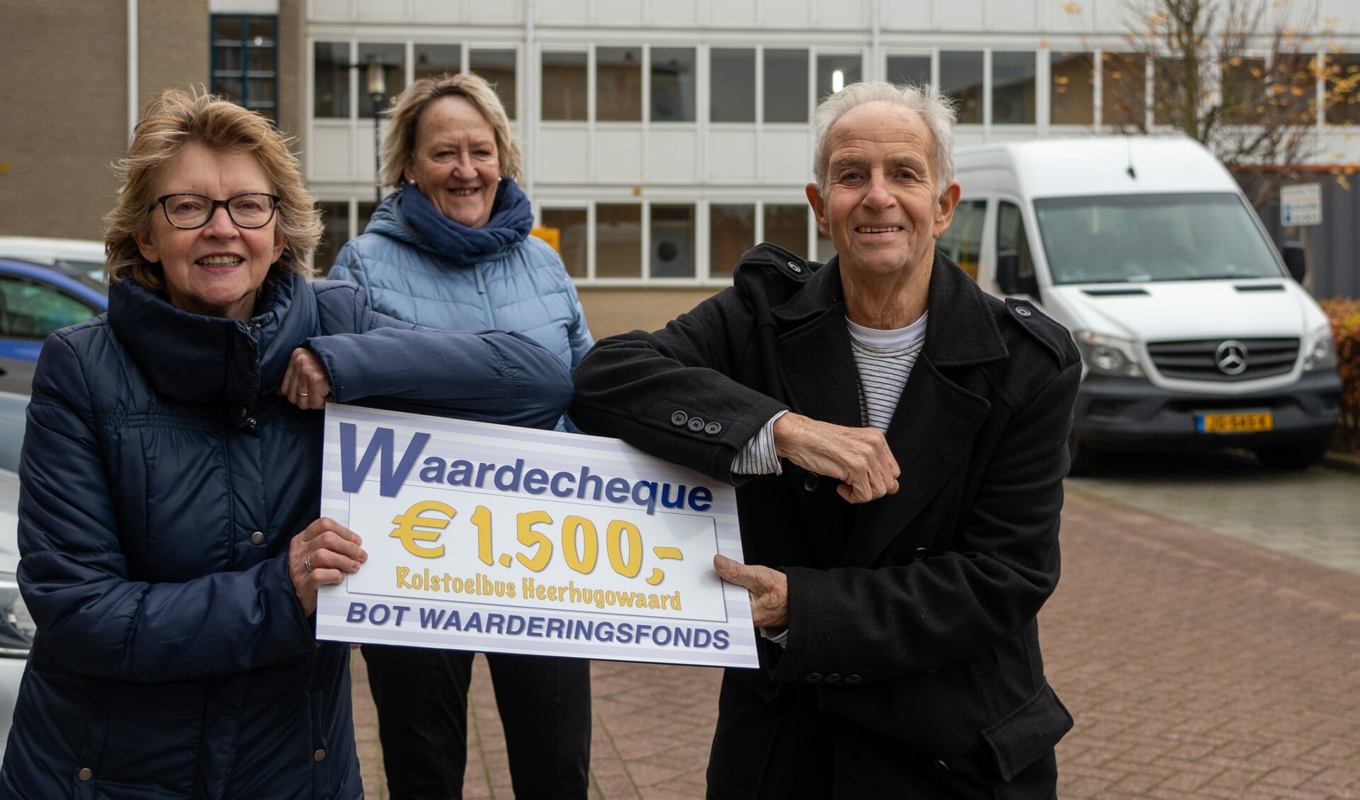 Annemiek van der Gragt (l) en Nel Nooter van Rolstoelbus Heerhugowaard nemen de cheque in ontvangst uit handen van Frits Weel van het Bot Waarderingsfonds.