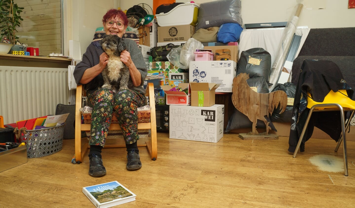 Ivonne met één van haar hondjes, met op de achtergrond de ingepakte spullen die ze meeneemt naar haar tiny house.