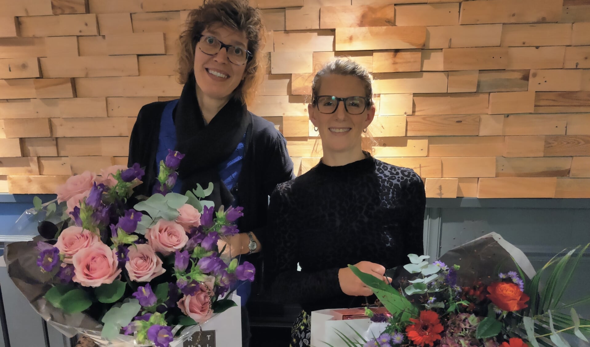 Lissy Baars (l) en Mirjam Vertelman in de bloemen na jaren trouwe dienst als bestuurslid van TAV’80. 