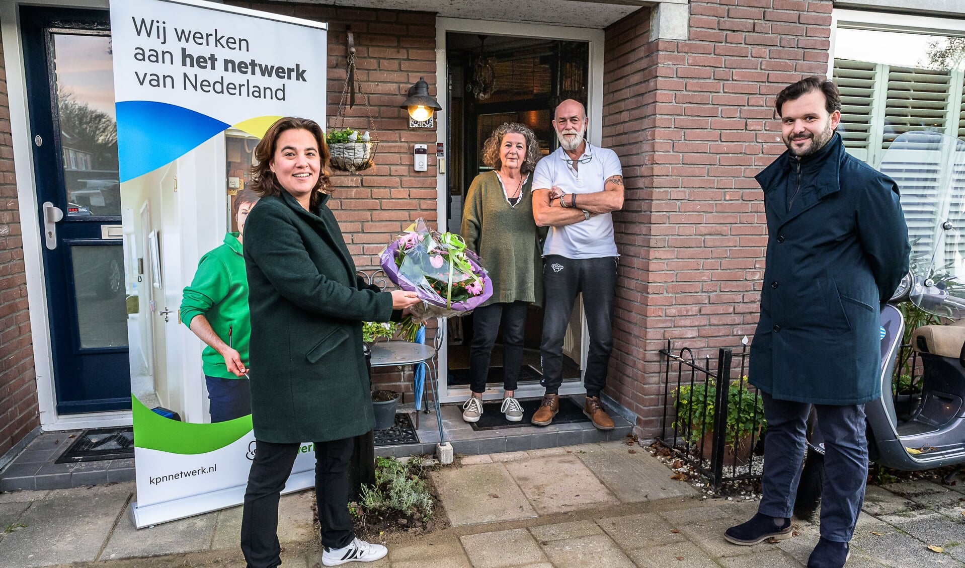 Wethouder Eveline Tijmstra (l) en José Moure Sanchez van KPN zetten de familie van Selm in de bloemen. Zij werden als eerste in de wijk Purmer-Noord op het glasvezelnetwerk aangesloten.