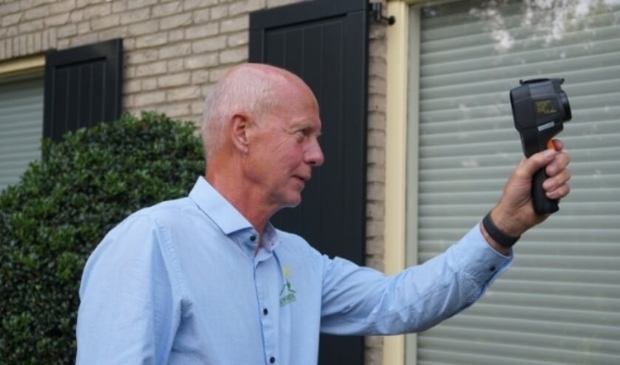 <p>Vrijwillig energiecoach Ton Kos demonstreert de warmtebeeldcamera, waarmee energieverlies gemeten wordt. </p>