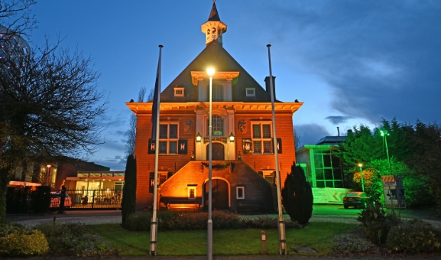 <p>Een prachtig plaatje, een verlicht raadhuis in oranje gekleurd.</p>