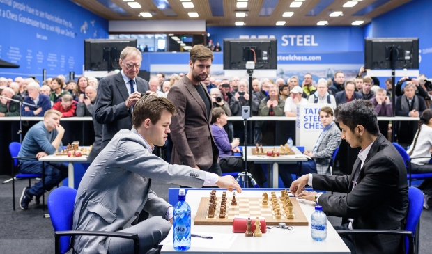<p>Vidit (rechts) tijdens het Tata Steel Chess Tournament 2019, tegen wereldkampioen Carlsen waarbij schaakliefhebber Nick Schilder toekijkt. </p>