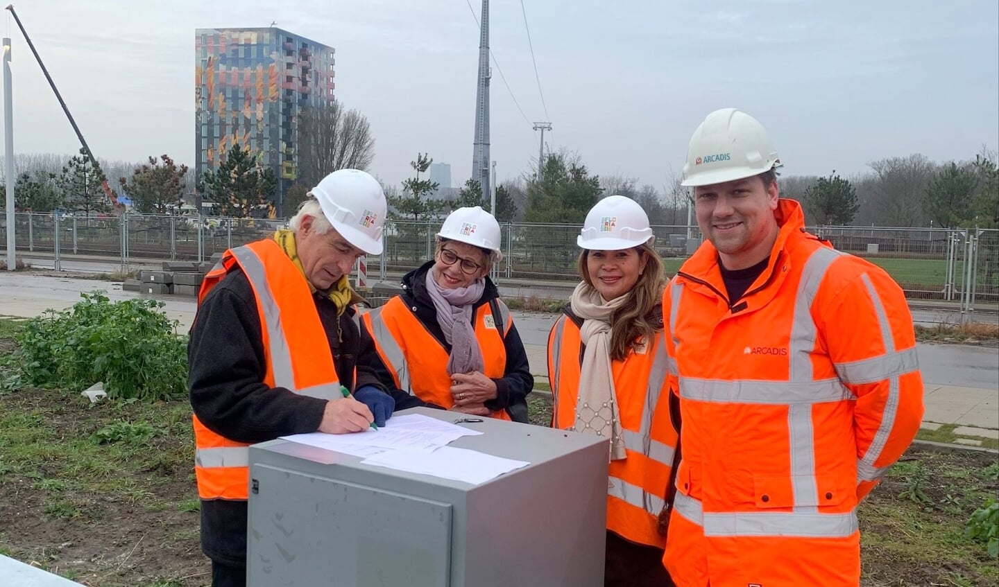 Michiel Gerritsen (li) zet namens Greenport Boskoop zijn handtekening, op het Floriadeterrein in Almere. Naast hem Helma van der Louw (Greenport), Rosalie Kambong en Patrick Smit (beide Floriade).
