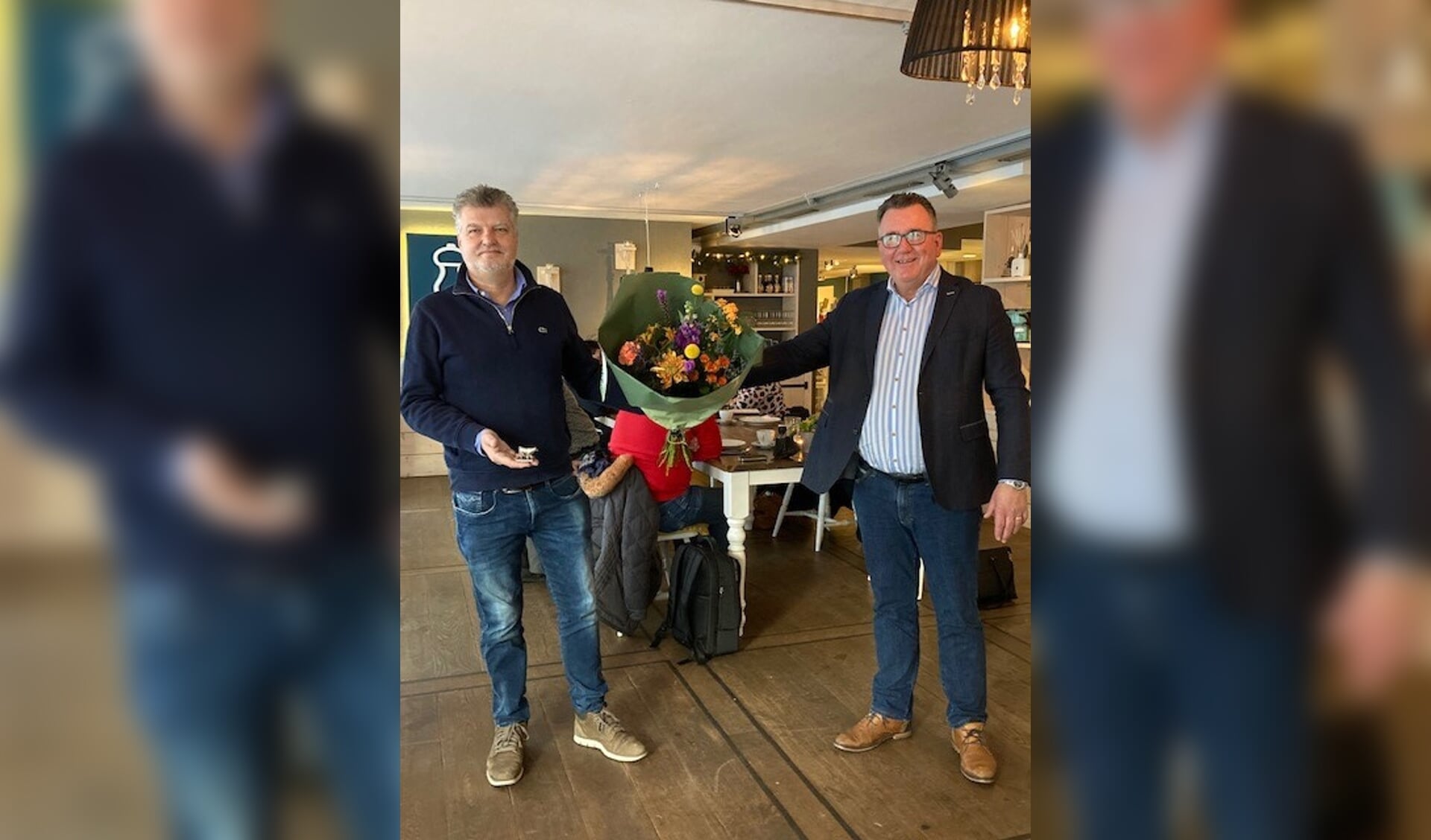 Wethouder Mario Hegger overhandigt Richard Gort bloemen bij zijn afscheid. 