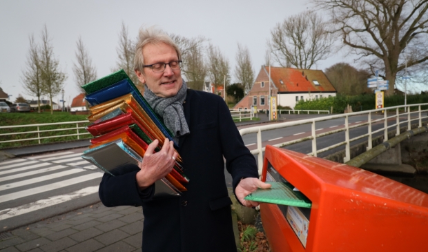 <p>Dirk Kuipers deponeert een kerstgroet in brievenbus.</p> 