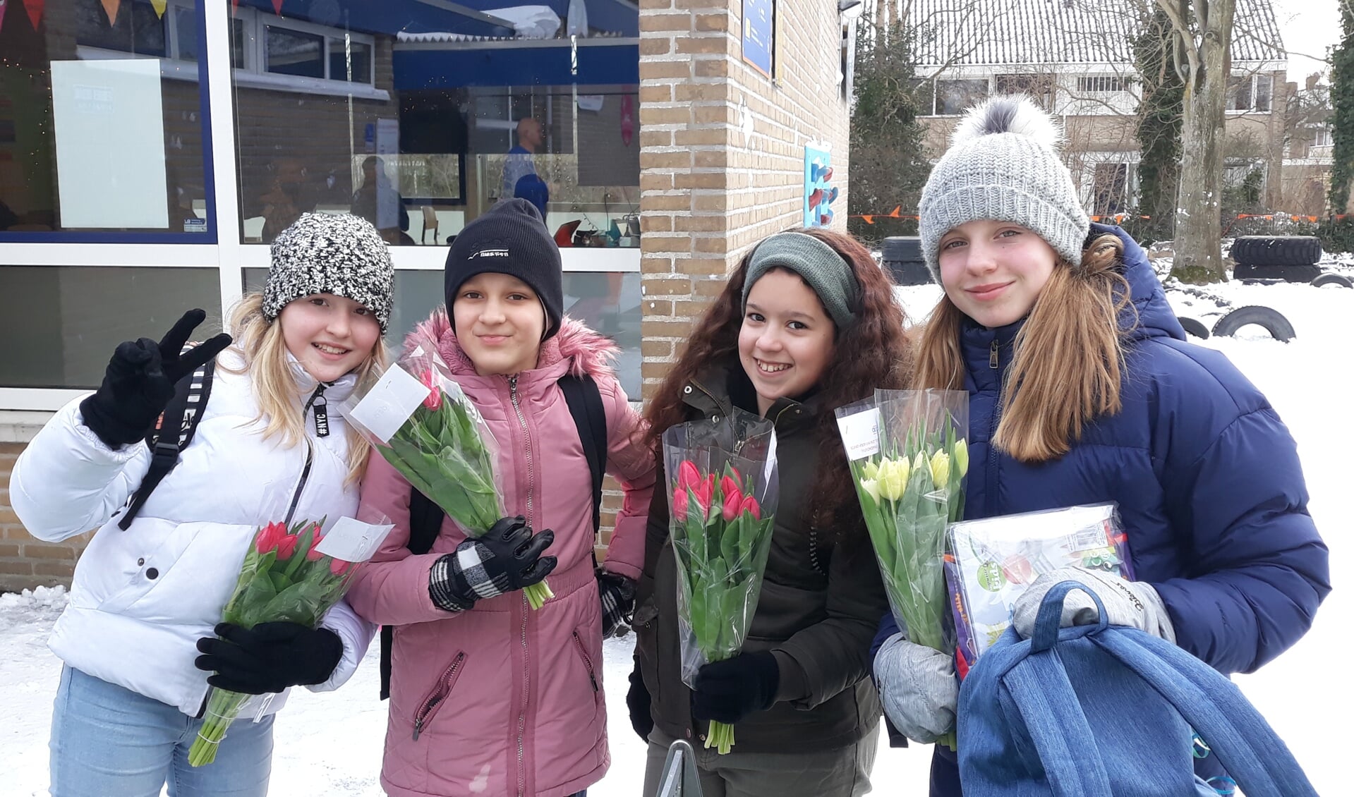 Leerlingen van De Duif met een vrolijke bos tulpen voor hun ouders, als bedankje voor de inzet en begeleiding tijdens de schoolsluiting.