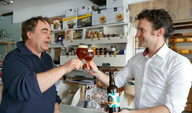 <p>Jelle Beemsterboer (rechts) proost met zijn eigen gebrouwen bier.</p>