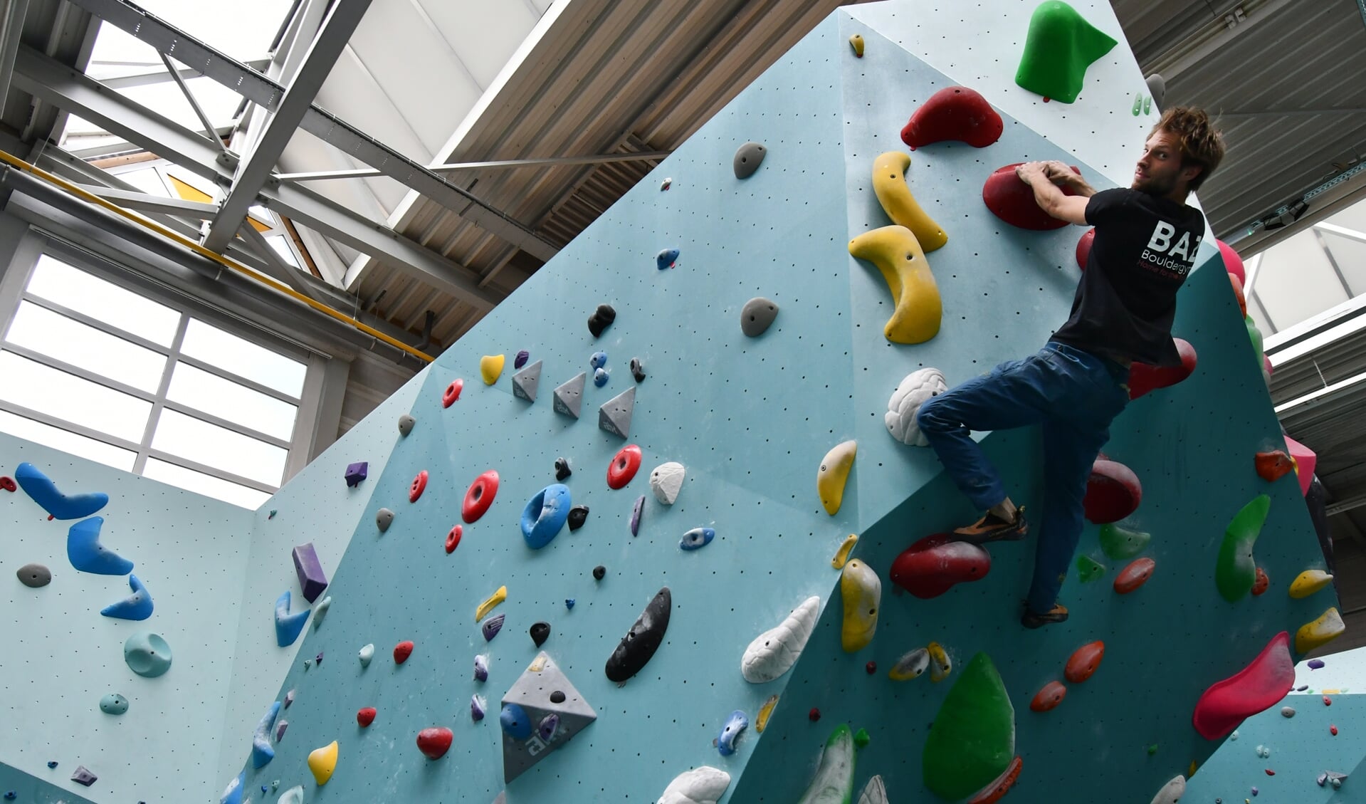 Bas Jonker, mede initiatiefnemer van BAZ Bouldergym, klimt als een berggeit omhoog. Het bijzonder gave indoor klimcentrum heeft bij De Hellema onderdak gevonden in de Oostzijde.  
