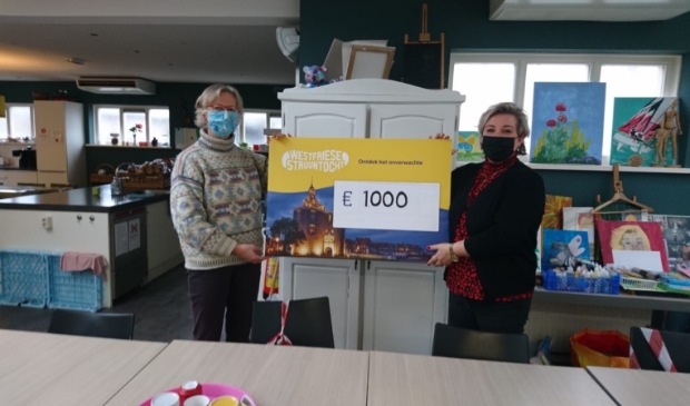 <p>Hanneke Borst overhandigt namens Stichting Westfriese Struuntocht de cheque aan Debbie van Dokkum van De Baanbreker in Enkhuizen.</p>