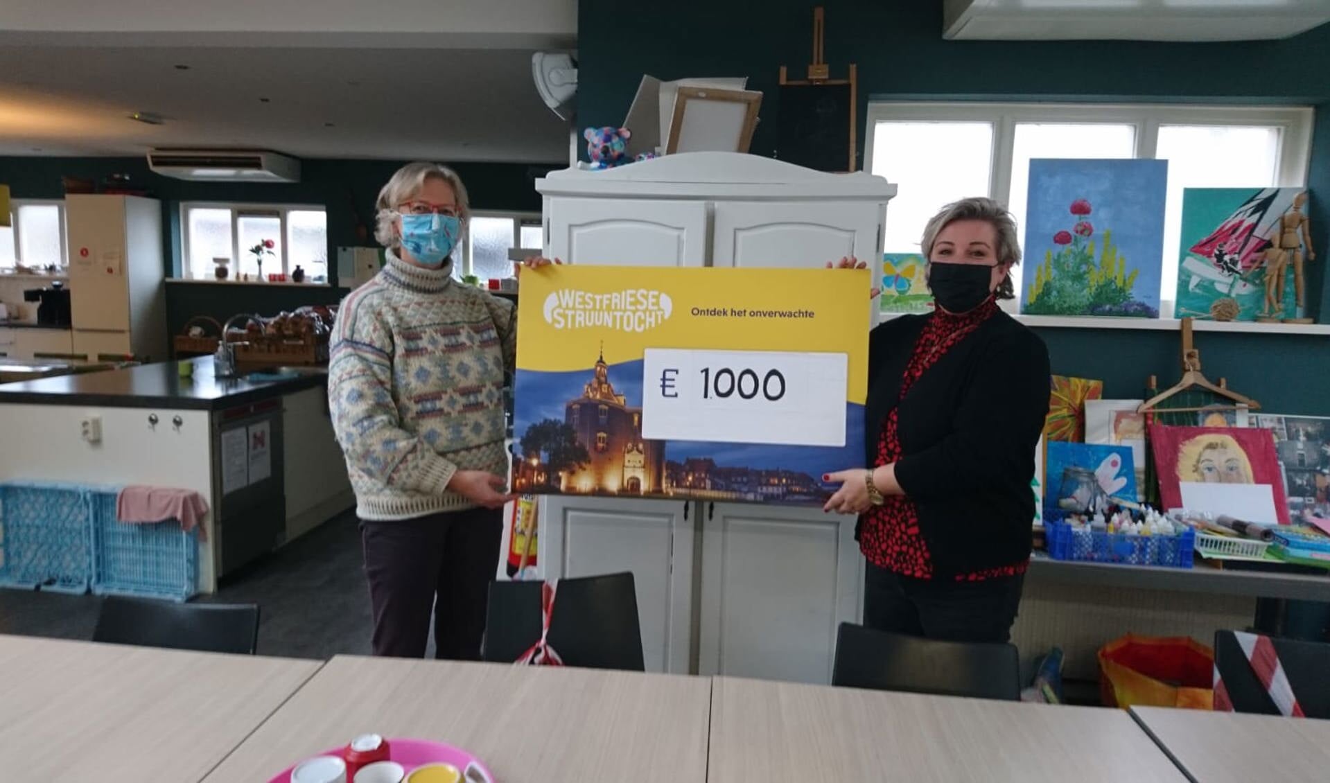 Hanneke Borst overhandigt namens Stichting Westfriese Struuntocht de cheque aan Debbie van Dokkum van De Baanbreker in Enkhuizen.