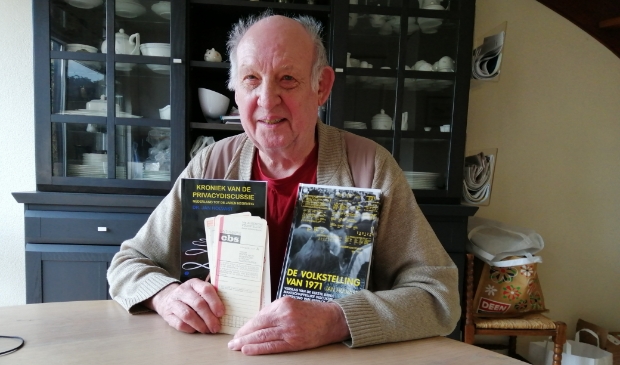 <p>Jan Holvast met twee van zijn boeken en een aantal ponskaarten, die vijftig jaar geleden werden gebruikt voor het vastleggen van persoonsgegevens.</p>
