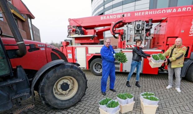 <p>De plaatselijke brandweer kreeg van kweker Marco Kroon (in blauwe overall) bossen tulpen uitgereikt.</p>