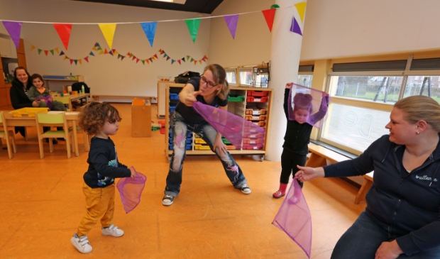 Muziekjuf Jessica (m) danst met peuters van de Kleine Braam.