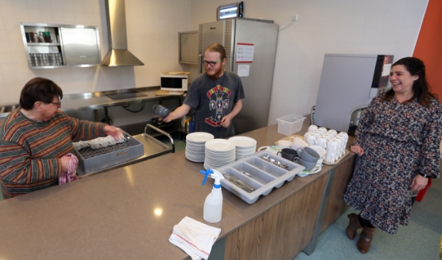 <p>Rick begeleidt Sjaan (l) bij het werk in de kantine. Jobcoach Dani kijkt toe. "Mensen versterken in hun eigen kracht, dat is ons doel."</p>