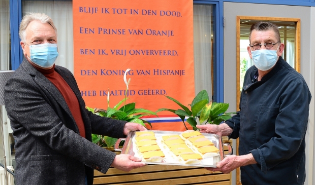 <p>Op woonzorglocatie Schoterhof werden de tompouces door voorzitter van het Oranje Comité Frank Heerens overhandigd aan kok Evert de Boer.</p>