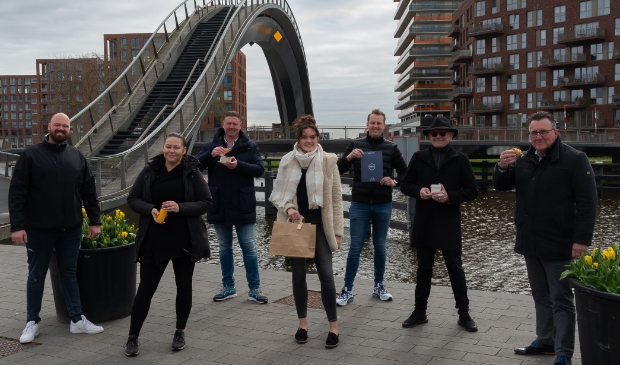 <p>De deelnemende horeca-ondernemers en wethouder Mario Hegger voor de Melkwegbrug.</p>