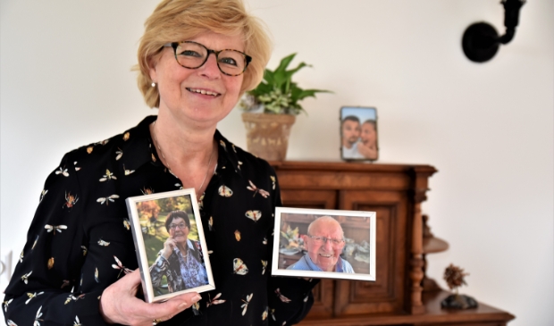 <p>Ineke met foto’s van haar moeder Bep en vader Cor.</p>