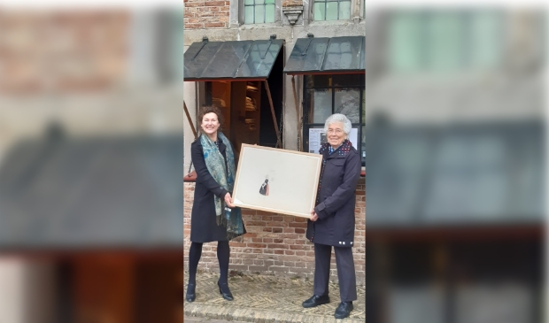 <p>Conservator Julie Hengeveld en mevrouw Van Erp Taalman Kip-Nieuwenkamp, kleindochter van W.O.J. Nieuwenkamp laten een van de tekeningen van W.O.J. Nieuwenkamp zien. </p>