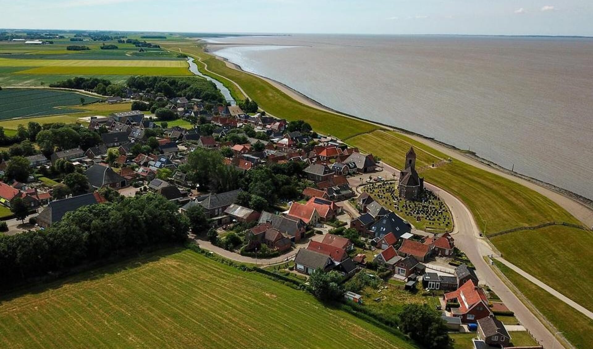 Zicht op Wierum aan de Waddenzeedijk.