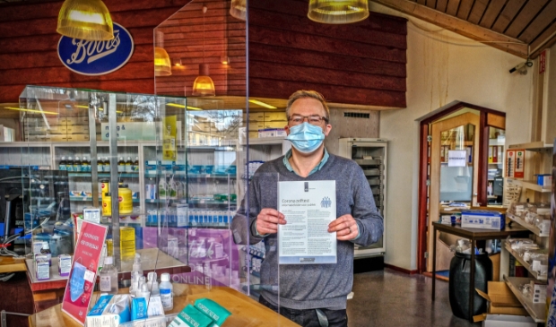 <p>Apotheker Kees Blanksma toont de informatie van de Rijksoverheid die bij de test wordt geleverd.</p>