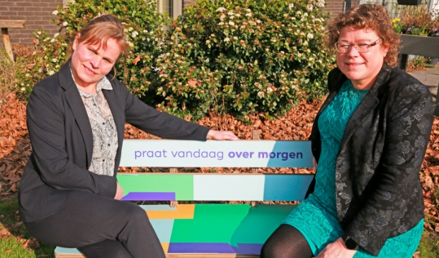 Gabriele Kasten van Pieter Raat (l) en wethouder Annette Groot praten op het 'Over morgen'-bankje over de toekomst van de ouderenzorg in Heerhugowaard.